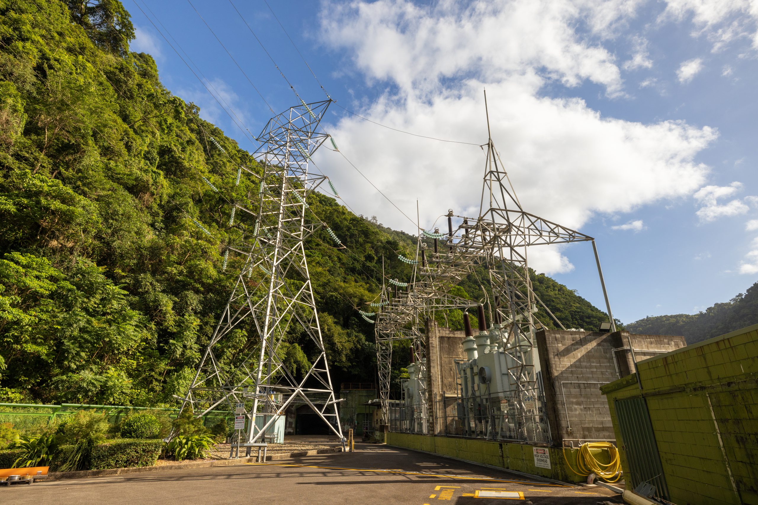 Barron Gorge substation and transmission tower on a bight sunny day, surrounded by greenery.